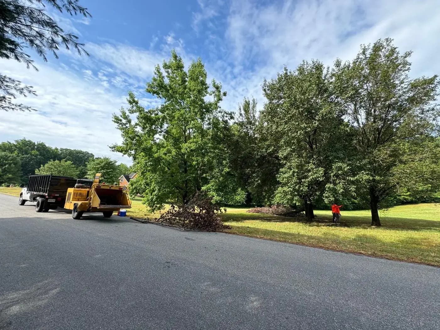 MG Tree Service dump truck and wood chipper parked at a residential tree job in Richmond, VA