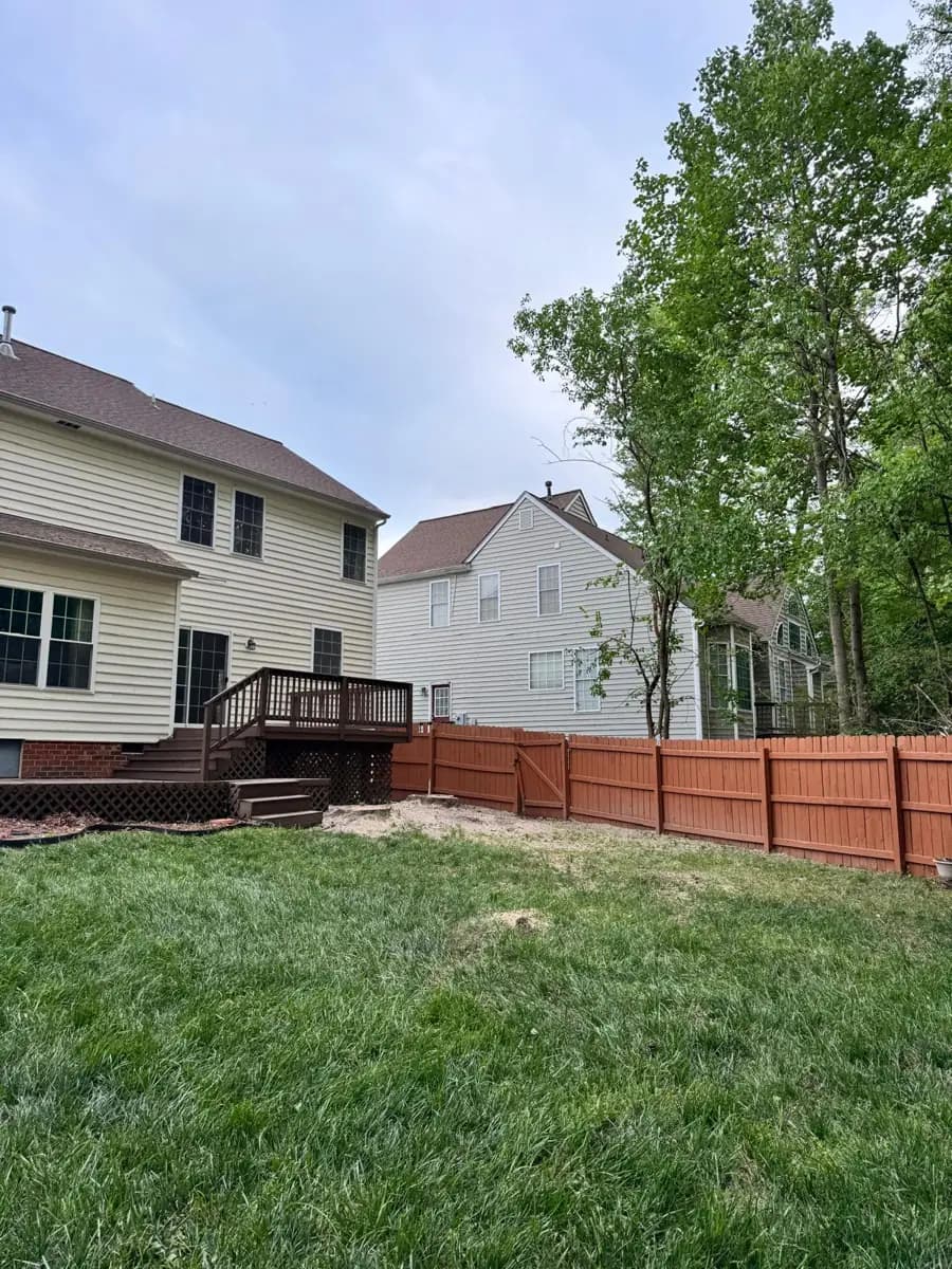 After: the backyard cleaned up, with the house, deck and fence intact